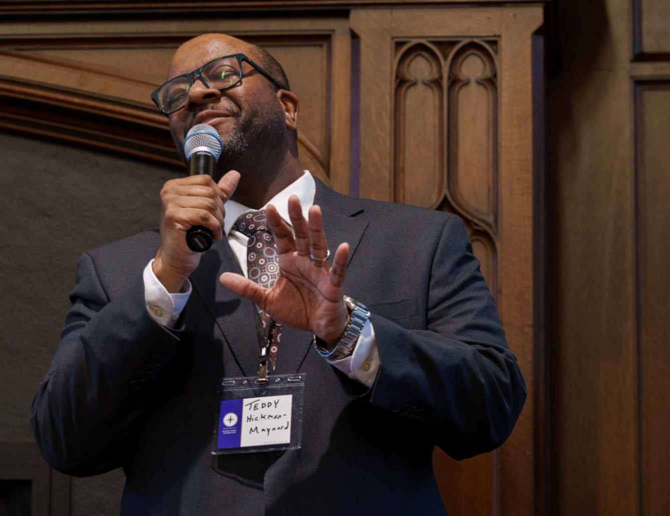 Speaker addressing the audience with a microphone at the summit